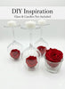 Decorative glass holders with red roses and white candles on a white background