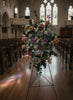 soft tone roses with baby breath standing spray place in a church