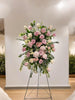 Pastel Floral arrangement on a stand against a white wall
