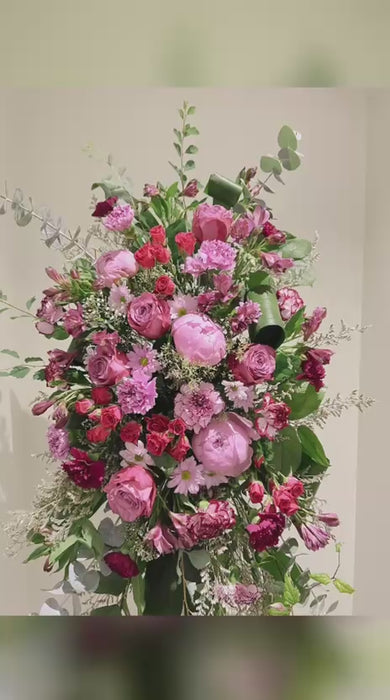 Elegant pink and white funeral sympathy standing spray featuring roses and premium focal flowers  ,  and lush greenery on an easel—crafted by Chez Joy Florist in the Greater Toronto Area.