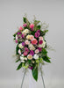 sympathy standing spray .Colorful flower arrangement with pink, purple, and white flowers on a stand.