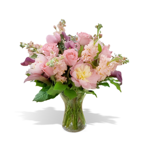 Delicate pastel floral arrangement featuring pink roses, peonies, calla lilies, and stock flowers, elegantly arranged in a clear glass vase. Perfect for weddings, anniversaries, or thoughtful gifts, available at Chez Joy Florist.